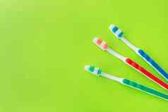 五彩缤纷的牙刷绿色背景概念牙科护理口服卫生的地方登记