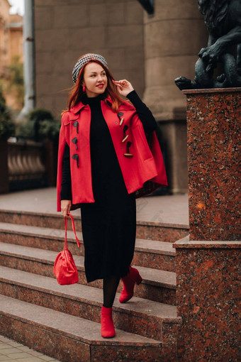 美丽的时尚的女人穿着优雅的红色的外套时尚的红色的手提包秋天<strong>城市</strong>