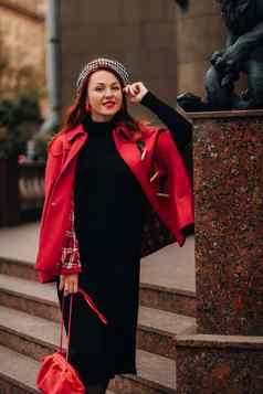 美丽的时尚的女人穿着优雅的红色的外套时尚的红色的手提包秋天城市