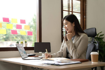亚洲业务女人计算器移动PC数学金融办公室桌子上税报告会计统计数据分析研究概念