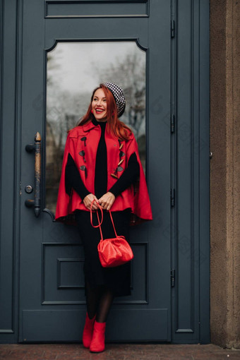 美丽的时尚的女人穿着优雅的红色的外套时尚的红色的手提包秋天城市