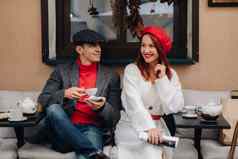 快乐时尚的夫妇饮料咖啡微笑坐着咖啡馆街