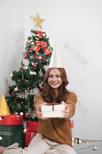 肖像微笑女孩持有礼物盒子坐地板上房子在室内x-mas圣诞节装饰