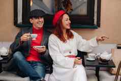 快乐时尚的夫妇饮料咖啡微笑坐着咖啡馆街