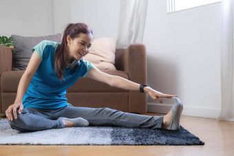 微笑亚洲女人瑜伽肩膀伸展运动在线类首页生活房间隔离锻炼首页科维德