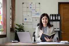 亚洲女商人会议办公室采取笔记平板电脑办公室