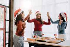 集团亚洲朋友收集庆祝圣诞节香槟吃披萨首页快乐假期聚会，派对朋友的同事概念