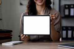 快乐亚洲女人显示平板电脑电脑空白屏幕坐着办公室模型广告