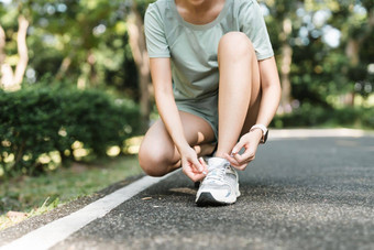 女人系鞋鞋带特写镜头女体育<strong>运动健身</strong>跑步者准备好了慢跑在户外