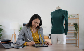 微笑设计师快乐设计师亚洲年轻的女人女孩移动PC电脑检查在线订单首页办公室出售时尚衣服老板启动企业家电子商务小锻造业务