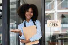 小业务非洲女老板微笑把标志开放咖啡馆快乐美国黑人女服务员企业家围裙现在标志通过