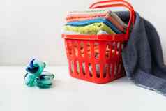 多色的毛巾谎言红色的洗衣篮子白色背景洗熨衣服衣服前视图