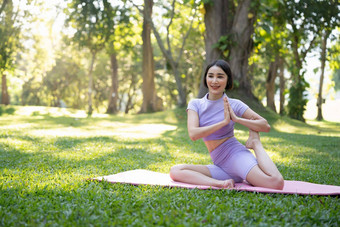有吸引力的年轻的亚洲女人实践瑜伽锻炼公园站腿瑜伽席显示平衡的姿势幸福生活方式活动概念