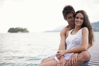 享受隐私码头充满深情的年轻的夫妇坐着码头