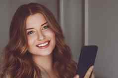 美丽的女人视频调用会说话的移动电话女孩在线购物智能手机