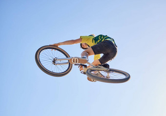 自行车骑自行车的人男人。跳肾上腺素迷骑竞争Copyspace极端的体育运动自行车骑自行车男人。特技自行车蓝色的天空背景