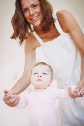 婴儿步骤妍准备好了走肖像妈妈。帮助婴儿女儿步骤