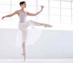 控制完美优雅的年轻的芭蕾舞女演员白色跳舞尖端