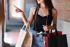年轻的女人旅行者携带购物袋工作购物购物中心