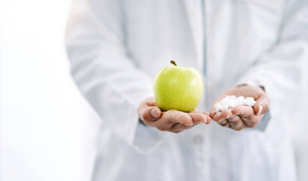 重要的财富健康特写镜头拍摄unrecognizale医生持有苹果各种药片手