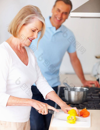 高级女人准备食物男人。背景厨房肖像高级女人准备食物男人。背景厨房