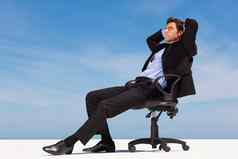 放松业务男人。坐着办公室椅子放松业务执行坐着办公室椅子清晰的天空