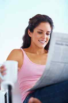 年轻的女人阅读报纸肖像年轻的女人阅读报纸杯咖啡