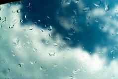 水滴玻璃蓝色的天空多雨的季节概念窗口视图背景屏幕保护程序