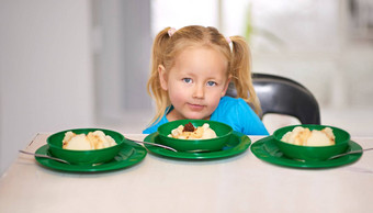 孩子饿了肖像女孩坐着餐厅表格食物提供志愿者