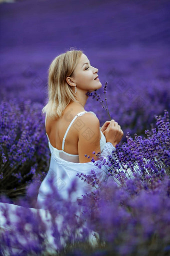 中年女人坐在薰衣草场享受芳香疗法芳香疗法概念薰衣草石油照片会话薰衣草