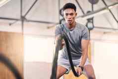 健身房战斗绳子培训黑色的男人。运动员有氧运动锻炼体育锻炼男人。健康绳子健康俱乐部权力能源强大的肌肉健身教练电梯