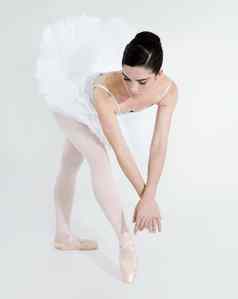 精致的优雅的柔软的年轻的芭蕾舞女演员跳舞白色背景