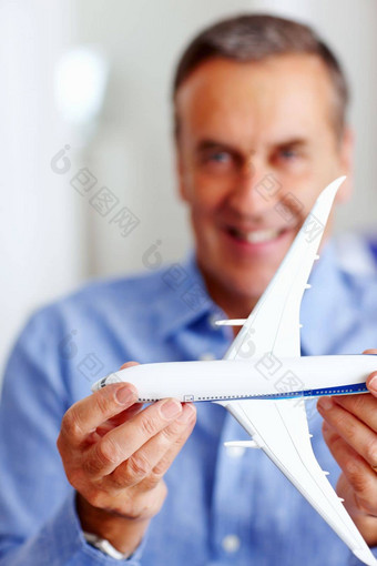 快乐高级男人。持有玩具飞机前面特写镜头肖像快乐高级男人。持有玩具飞机前面