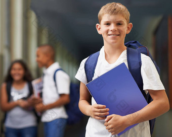 他<strong>勤奋</strong>的学生肖像快乐学校男孩站走廊朋友背景