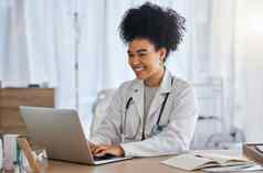 黑色的女人医生移动PC微笑医疗保健电子邮件远程医疗工作桌子上医院非洲美国女医疗专家微笑电脑医疗保险研究诊所