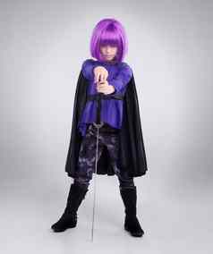 女孩超级英雄万圣节衣服摆姿势剑灰色工作室背景肖像女孩孩子玩超级英雄紫色的头发服装动漫真人秀战士睡魔