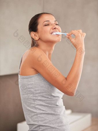保持珍珠白人珍珠白色美丽的年轻的女人刷牙牙齿浴室