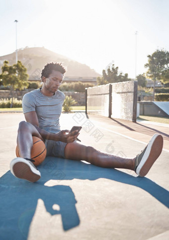 篮球电话男人。放松社会媒体互联网阅读新闻应用程序户外法院黑色的男人。智能手机体育运动培训锻炼游戏体育俱乐部夏天