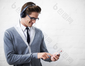 下载音乐智能手机年轻的男人。微笑电话听音乐耳机