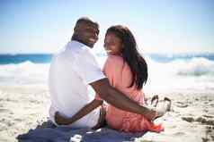亲密海滩快乐非裔美国人夫妇粗略的肩膀坐着海滩
