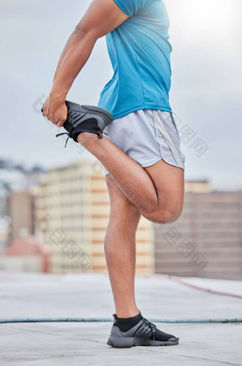 健身运行男人。伸展运动腿在户外开始马拉松培训有氧运动锻炼体育锻炼屋顶城市城市特写镜头强大的跑步者运动员温暖的身体健康