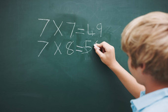 好数学年轻的男孩总结黑板上一块粉笔Copyspace