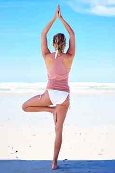 平衡生活年轻的女人瑜伽海滩
