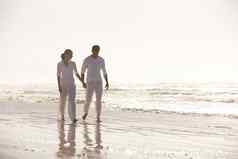 漫步海滩特殊的完整的长度拍摄有吸引力的年轻的夫妇穿着白色走海滩