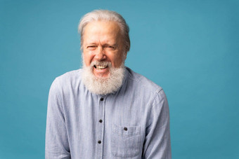退休男人。白色头发胡子笑声兴奋蓝色的颜色背景