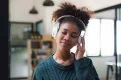 年轻的黑色的女人听音乐在线穿无线耳机享受最喜欢的首歌播放列表音乐应用程序