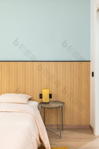 垂直视图床上枕头大温暖的羽绒被床单愉快的米色颜色现代设计墙木镶板表格灯黄色的框架软温暖的光晚上
