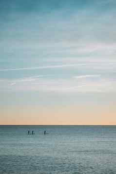 地平线行清晰的蓝色的万里无云的天空平静海洋满足距离人类轮廓桨冲浪者划船桨手