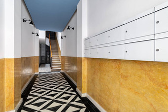 游说团体入口房子长走廊楼梯地板上黑色的白色大理石马赛克地板上明亮的黄色的墙灯黑色的金属灯罩邮箱