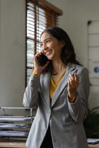 亚洲女商人会说话的客户端移动电话工作办公室